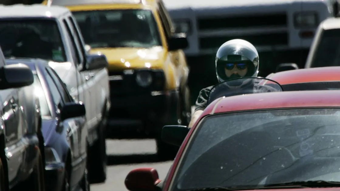 Motorcyclist riding between lanes in traffic on an Arizona road