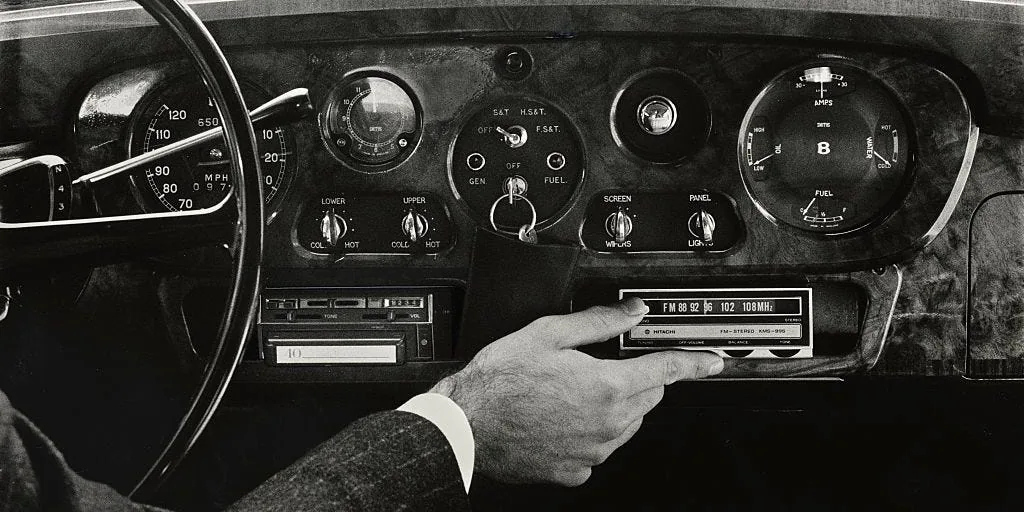 A car dashboard radio display with AM and FM tuning controls