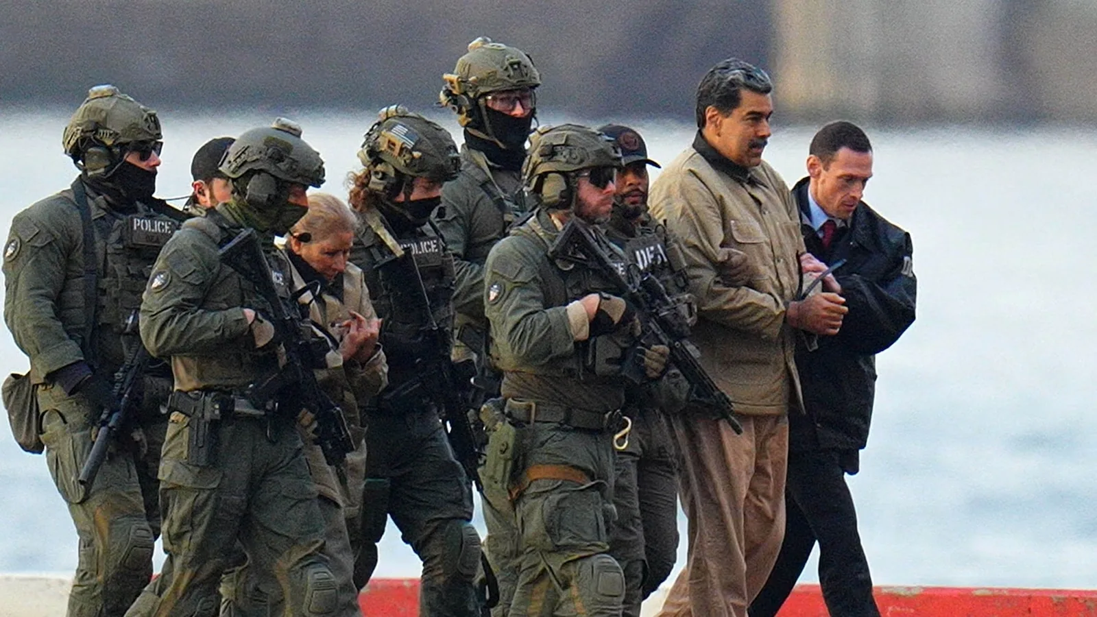 A soldier in military fatigues stands on the deck of a ship during the Maduro operation